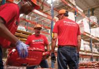 Purina employees working together in the manufacturing process