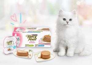 kitten standing next to a lineup of fancy feast wet kitten food products