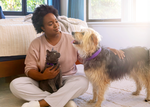 woman petting a dog and a cat