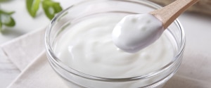 Yogurt in a bowl with a wooden spoon