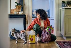 dog sitting next to her cat and tidy cats litter box